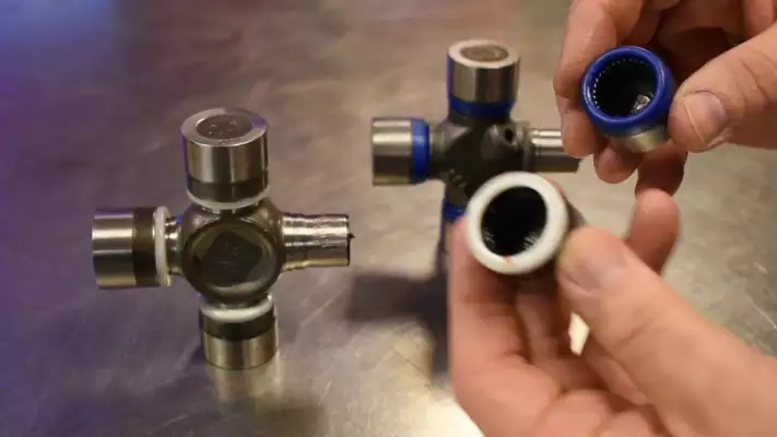 PTO shaft universal joint cross kit showing bearing cups and cross assembly for inspection and replacement
